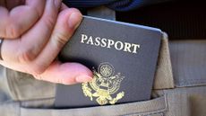 A man places his U.S. passport into his back pocket in Fresno, California.