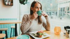 Woman happily eating in a restaurant alone