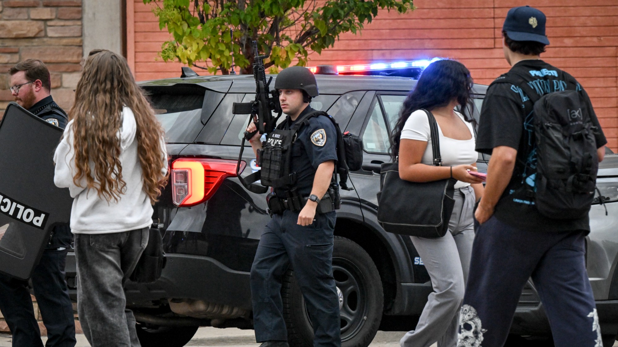 Students walk past police officers following a mass shooter hoax at the University of Colorado Boulder.